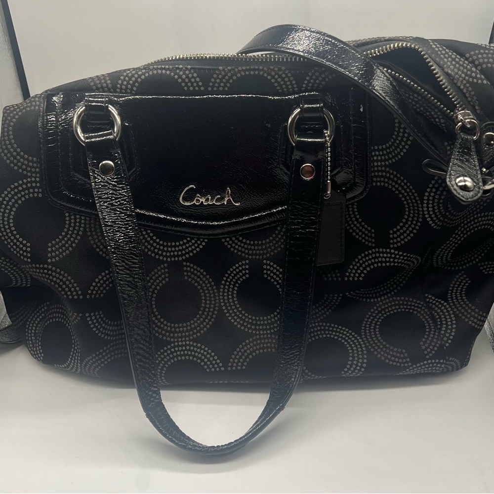 Black purse with shoulder and arm straps.  The purse has three inside pocket.